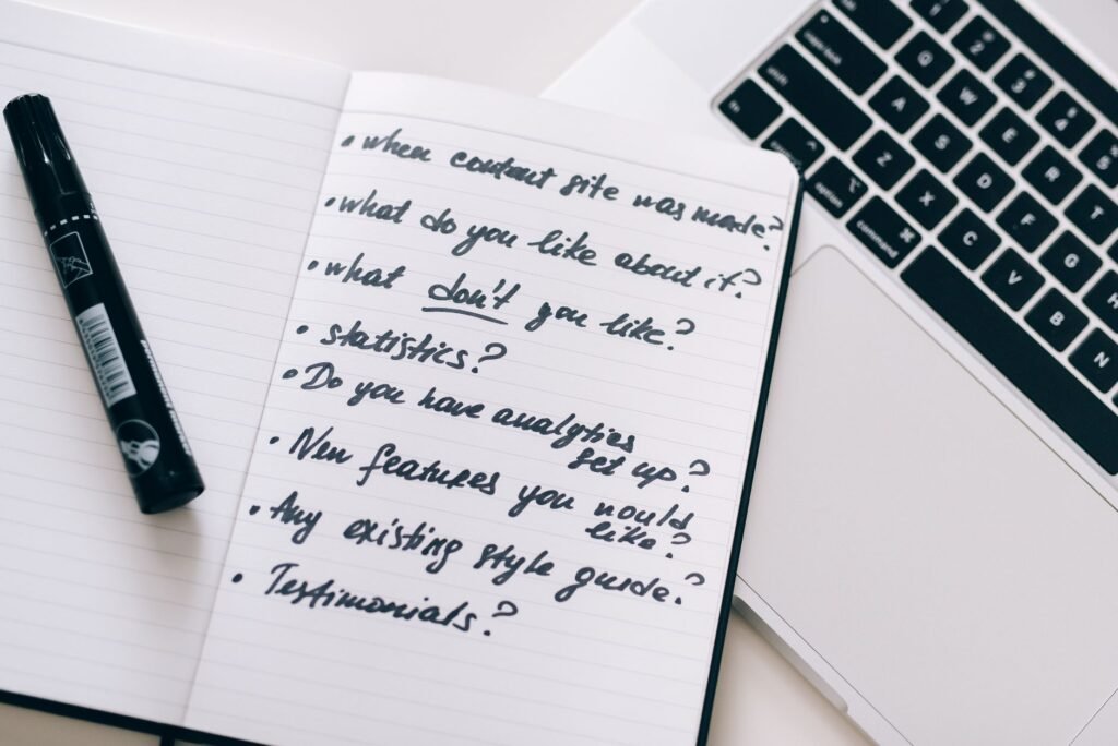 Close-up of a notebook with handwritten notes next to a laptop, ideal for business or educational content.