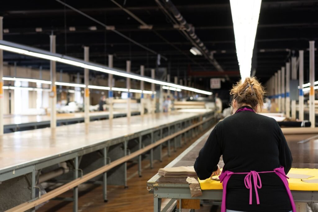 A worker in a textile factory focusing on production tasks. Industrial setting.