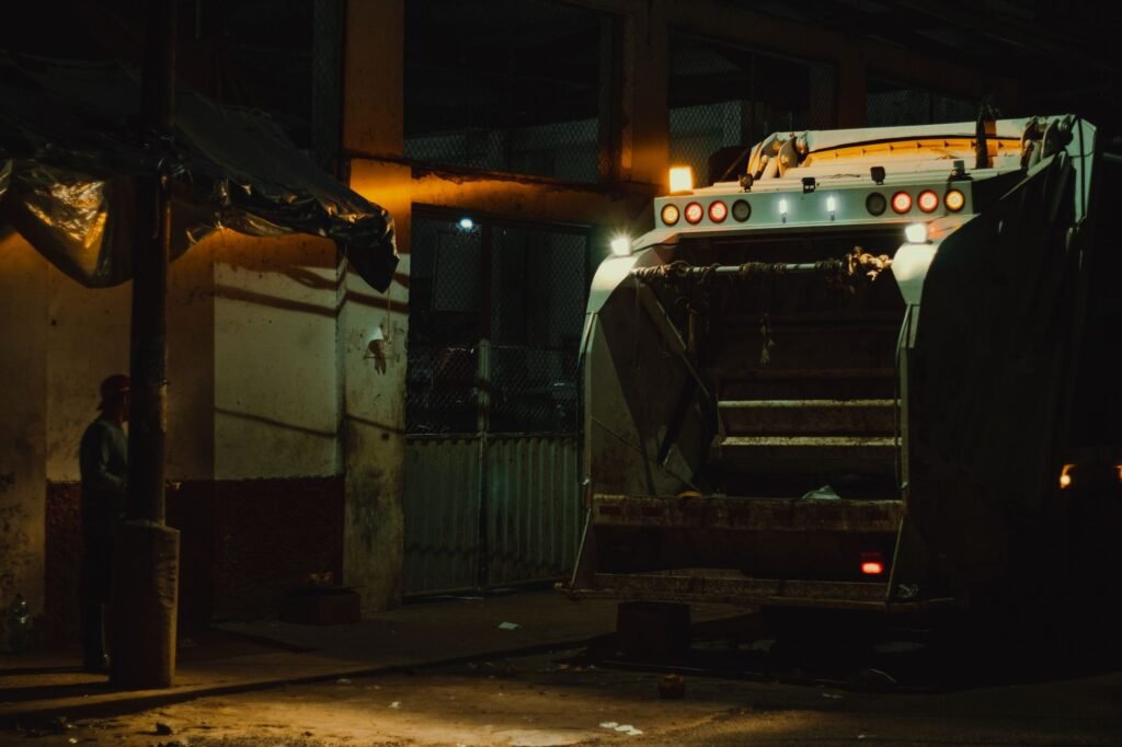 Garbage truck at night under city lights in Yurimaguas, Peru.