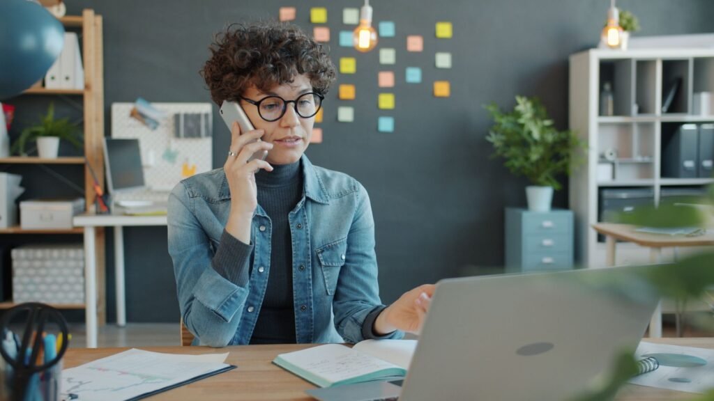 Confident professional woman multitasking in a modern office setting.