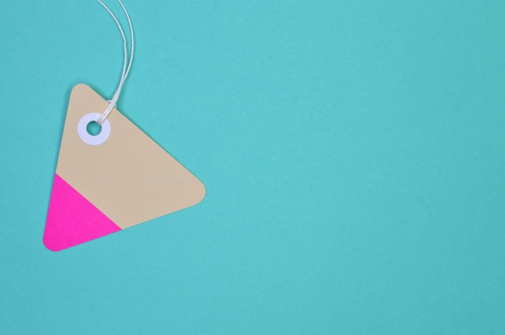 Minimalist image of a colorful triangle tag on a teal background, perfect for design projects.