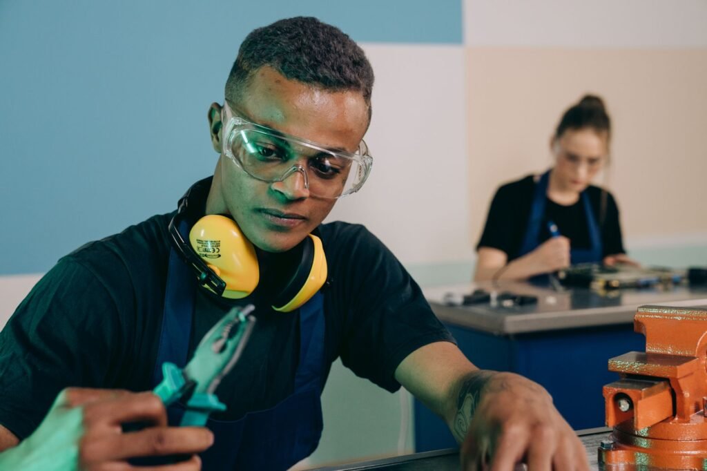Two technicians carefully working with tools in a modern workshop.